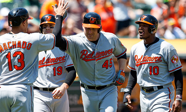OAKLAND, CA - AUGUST 11: Mark Trumbo #45 of the Baltimore Orioles is congratulated by Manny Machado #13, Chris Davis #19, and Adam Jones #10 after hitting a grand slam home run against the Oakland Athletics during the fifth inning at the Oakland Coliseum on August 11, 2016 in Oakland, California. The Baltimore Orioles defeated the Oakland Athletics 9-6. (Photo by Jason O. Watson/Getty Images)